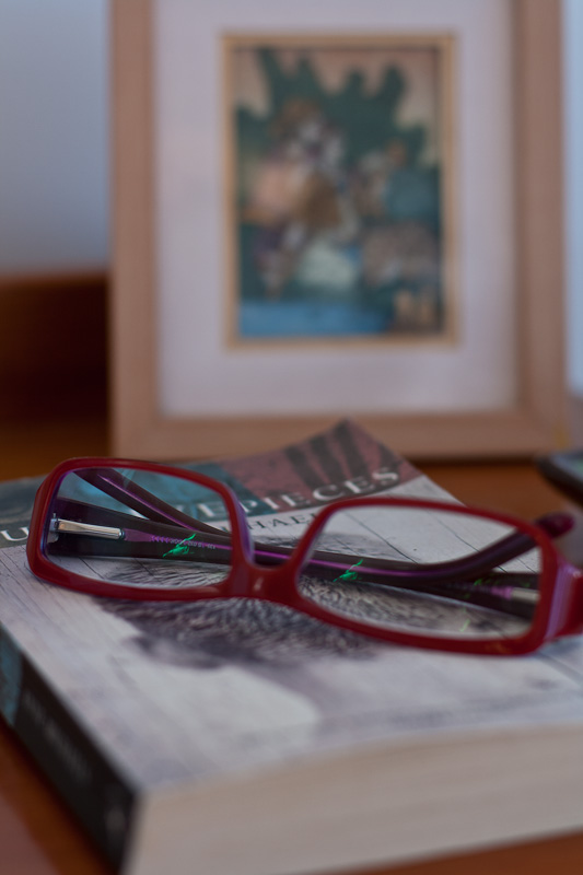 Book and spectacles on bedside table Book and spectacles on bedside table