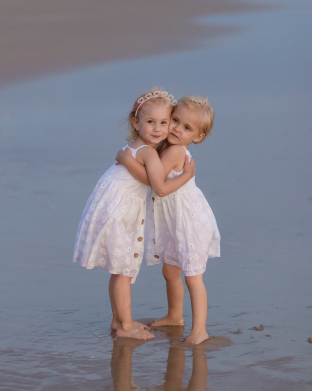 Two little girls hugging on a windy beach Sedgefield beach photoshoot