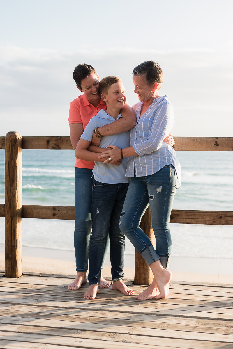 two mothers and their son playing on a beach at sunset in Sedgefield garden route during a photoshoot by moi du toi photography