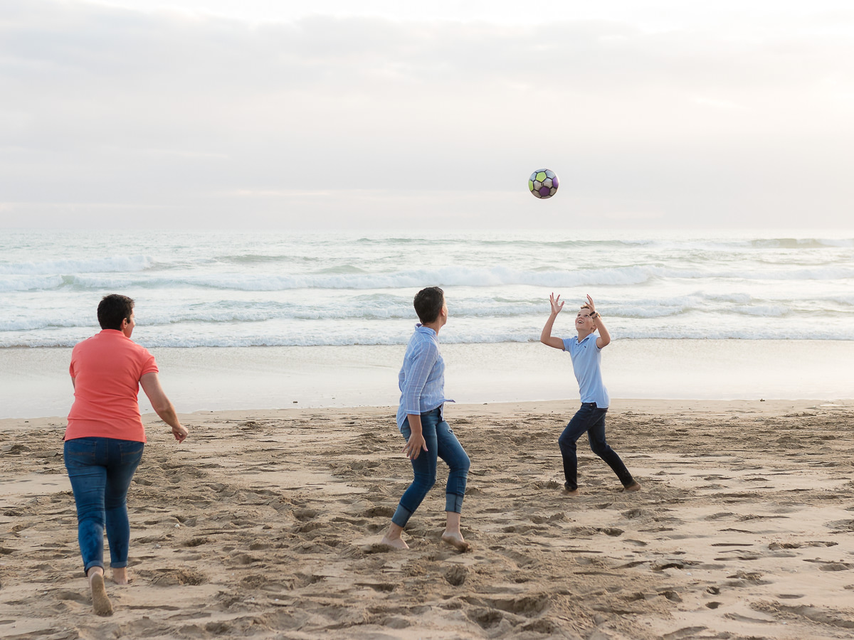 two mothers and their son playing on a beach at sunset in Sedgefield garden route during a photoshoot by moi du toi photography