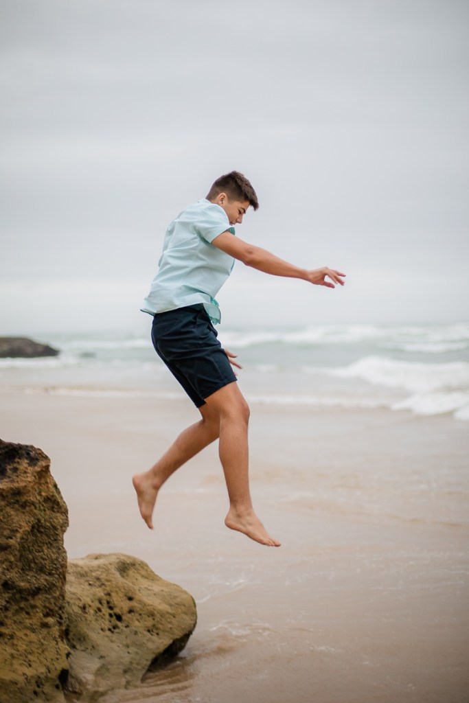teenage boy jumping beach family photo shoot brenton on sea knysna