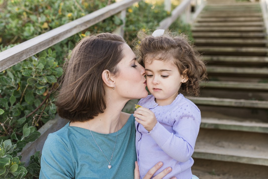 mom kissing little girl family photo session at Myoli Beach Sedgefield photo