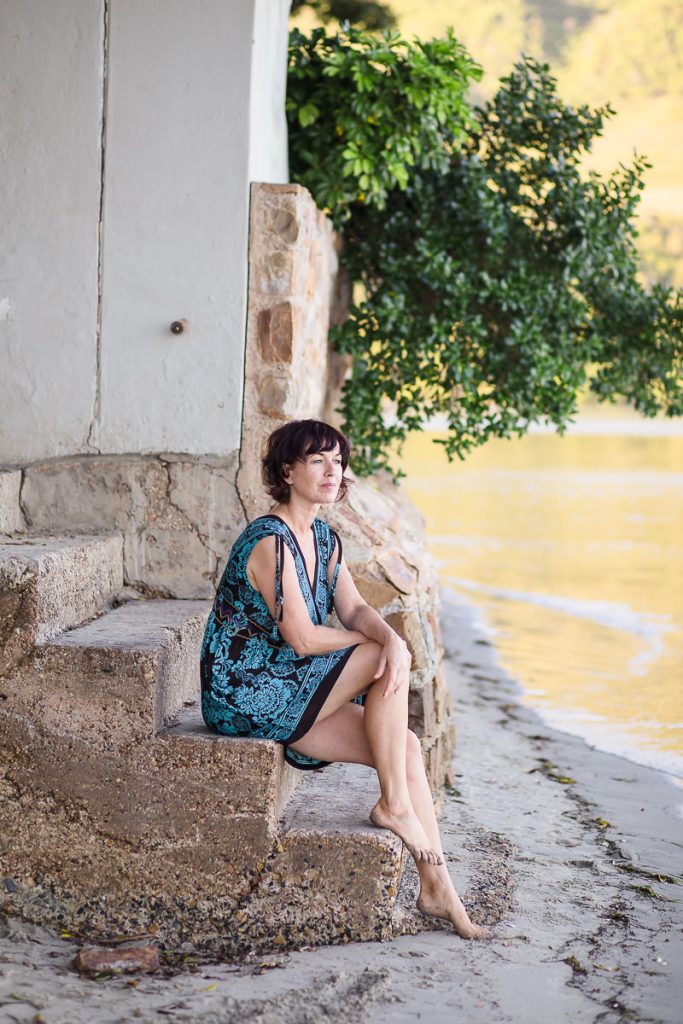 woman sitting on stone steps at Leisure Island Beach during personal branding session photographed by moira du toit of moi du toi photography