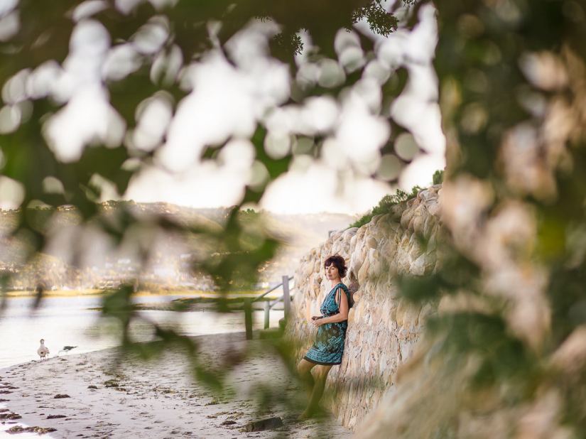 woman leaning against stone wall at Leisure Island Beach during personal branding session photographed by moira du toit of moi du toi photography