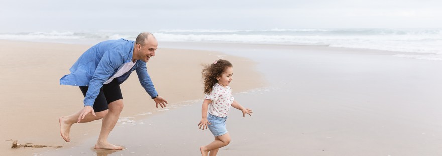 family playing on beach during light and airy family session at Cola Beach sedgefield photographer moi du toi