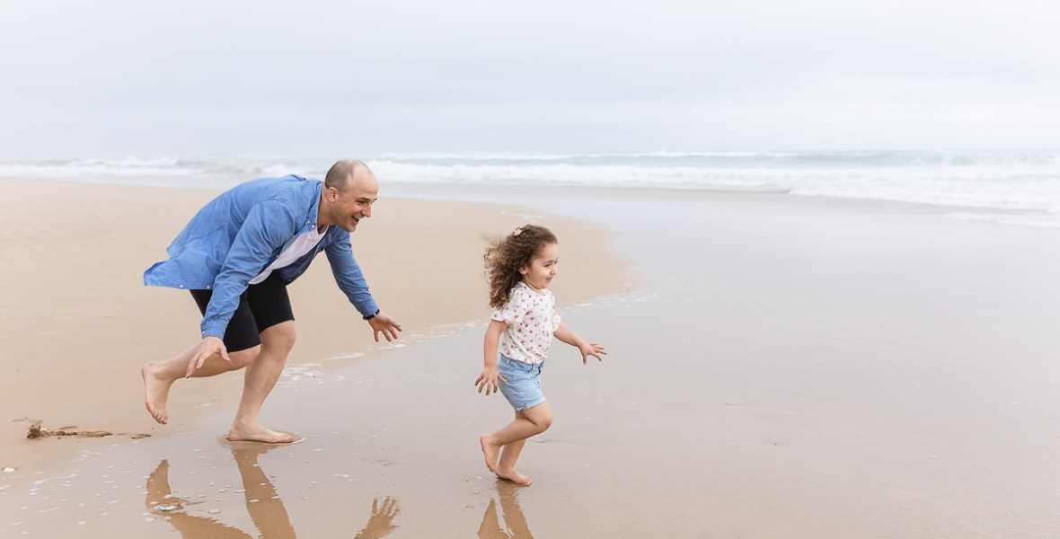 family playing on beach during light and airy family session at Cola Beach sedgefield photographer moi du toi