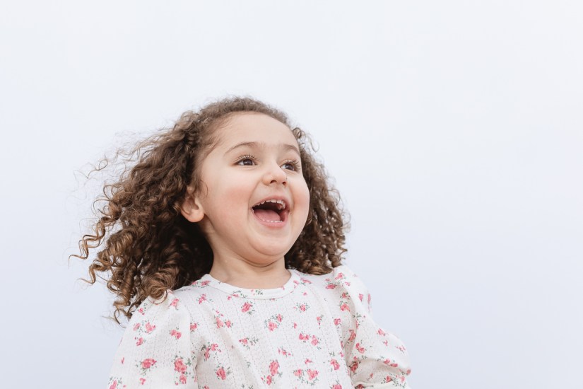 little girl laughing during light and airy family session at Cola Beach sedgefield photographer moi du toi