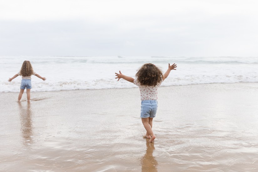 family playing on beach during light and airy family session at Cola Beach sedgefield photographer moi du toi