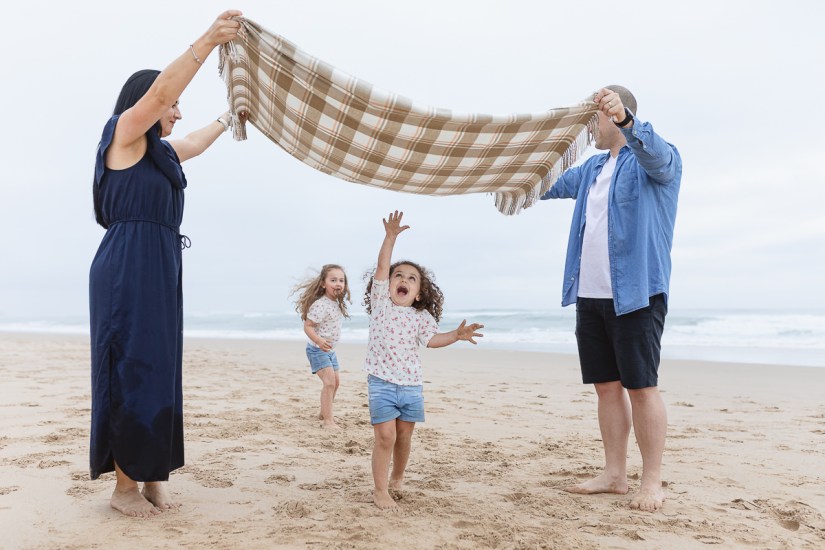family playing on beach during light and airy family session at Cola Beach sedgefield photographer moi du toi
