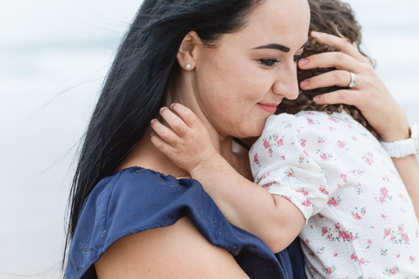 mother hugging child during light and airy beach family session at Cola Beach sedgefield photographer moi du toi