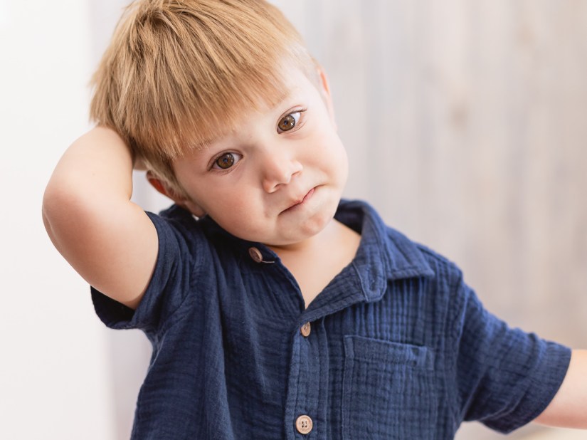 LIttle boy staring dreamily into space during light and airy slice of life family session at Cola Beach by sedgefield photographer moi du toi