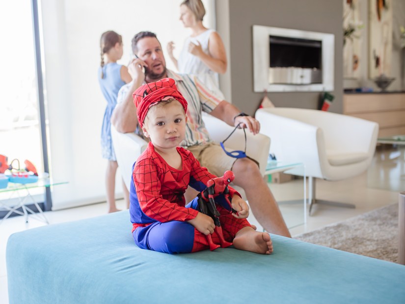 Little boy sitting on chair with spiderman outfit and action figure during light and airy slice of life family session at Cola Beach by sedgefield photographer moi du toi