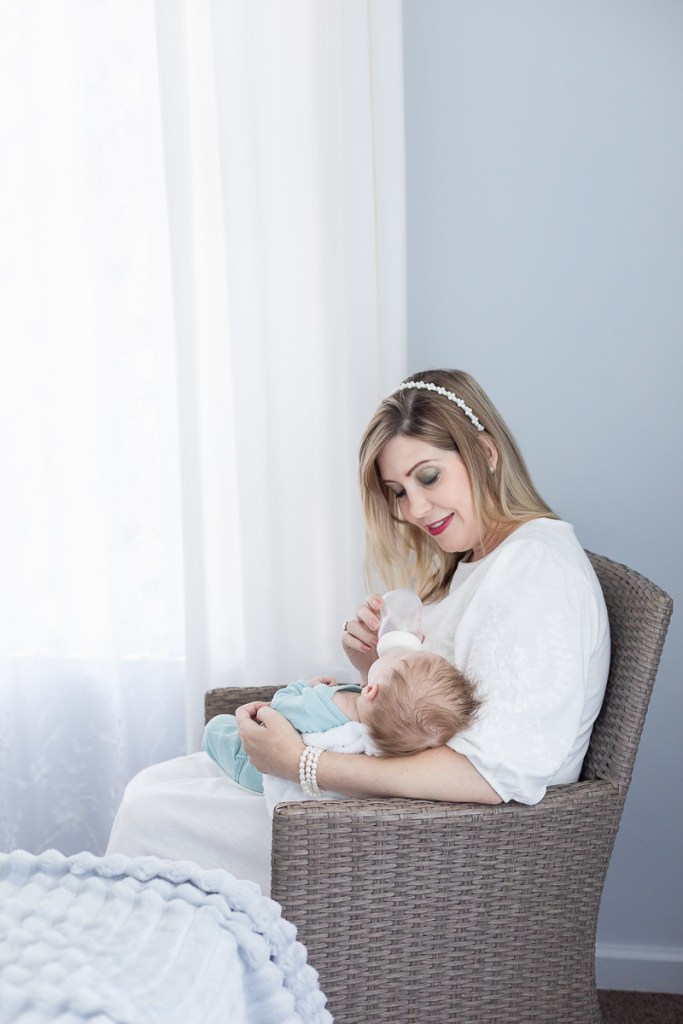 mother bottle feeding baby during lifestyle newborn photo session with photographer moi du toi photography